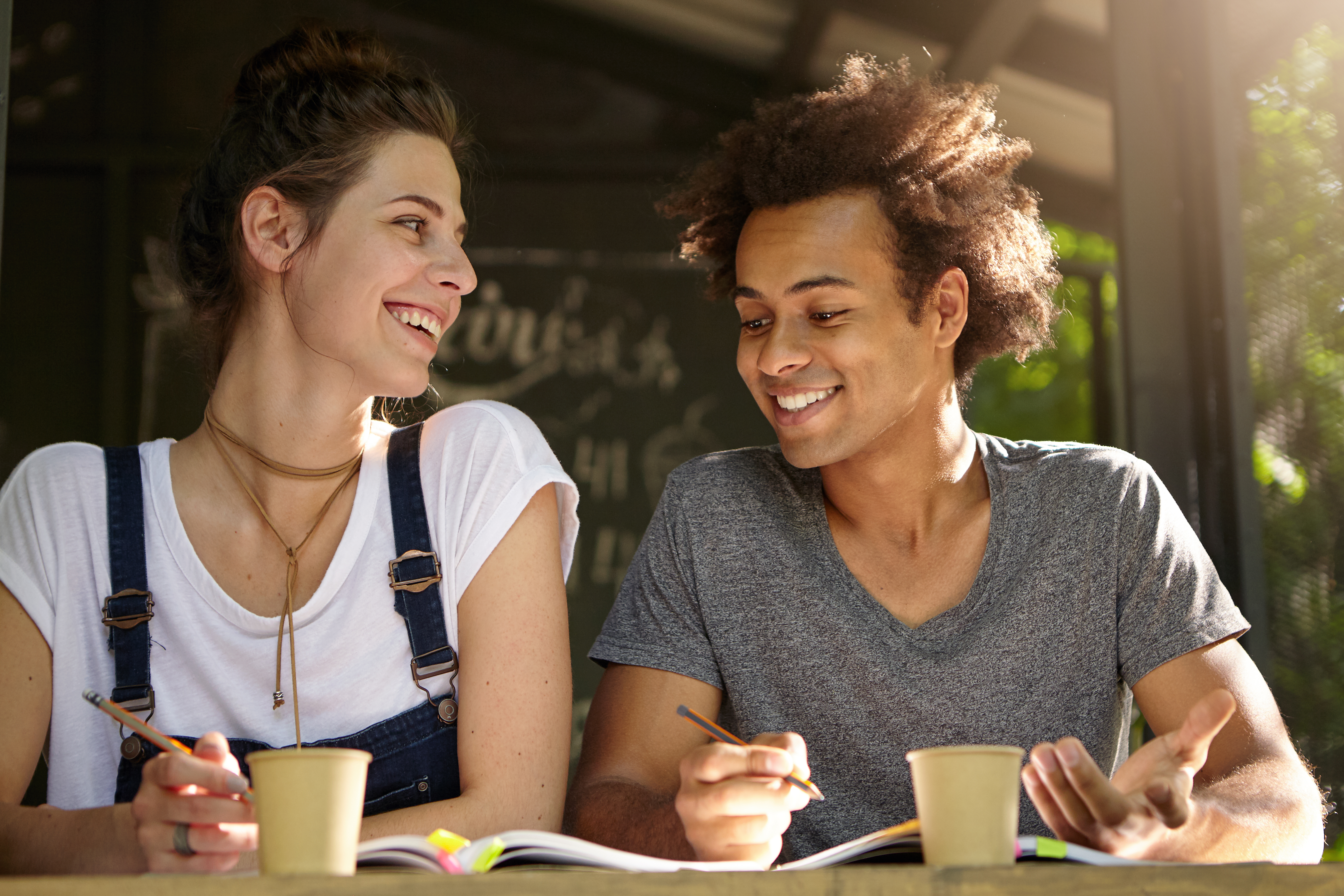 Two college interns working together over coffee.